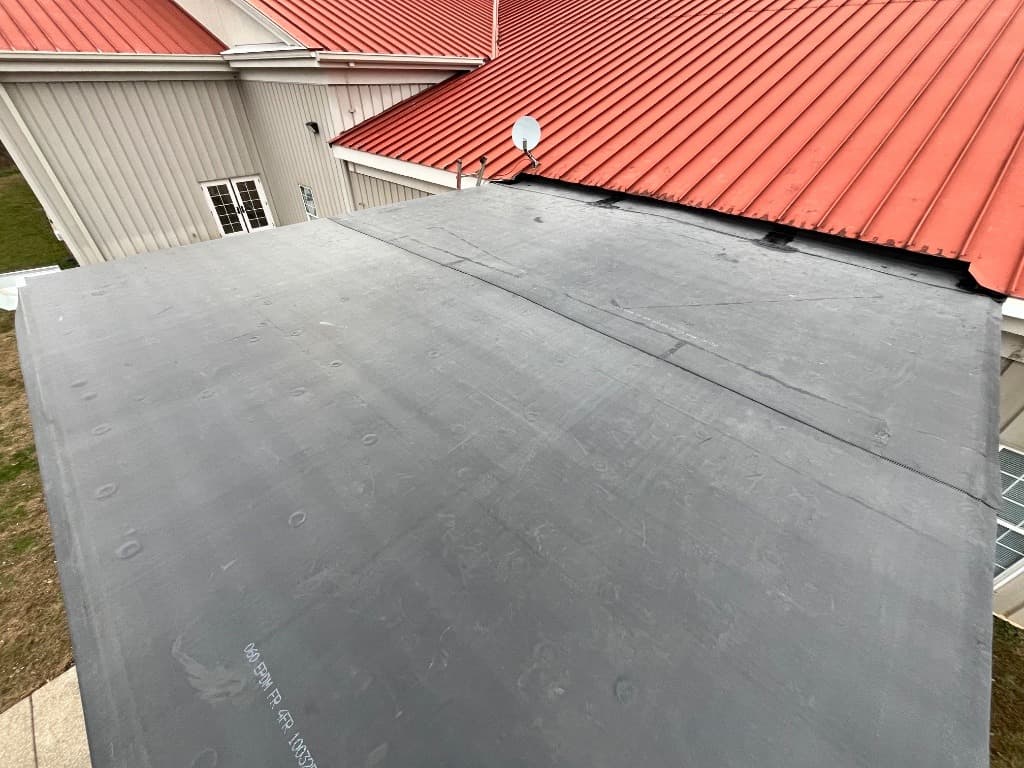 Black EPDM rubber membrane installation on a low-slope flat roof deck